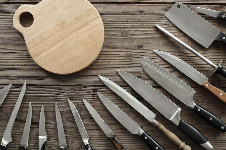 An-assortment-of-kitchen-knives-around-a-cutting-board-768.jpeg